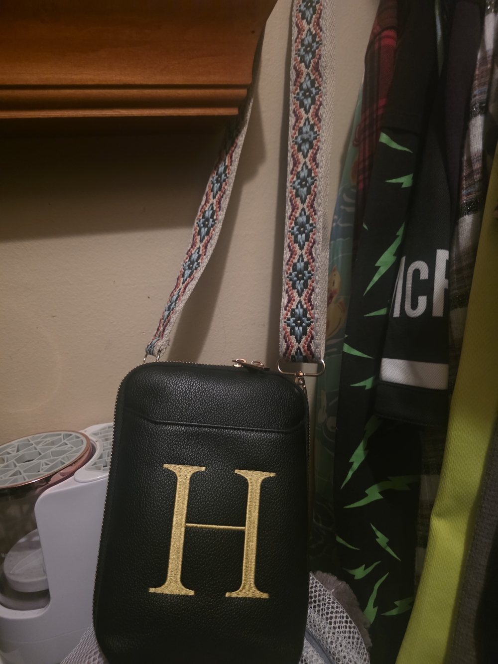 Black Crossbody Phone Bag with Gold 'H' Accent and Patterned Strap